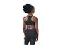 Femme de dos en brassière de sport noire et legging, regardant sur le côté.