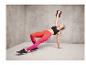 Une femme fait un exercice avec un kettlebell, portant des chaussures de running Saucony.