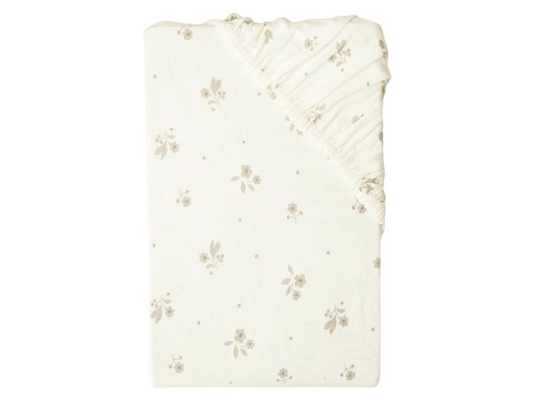 Drap-housse blanc cassé avec un motif floral discret et des pois.