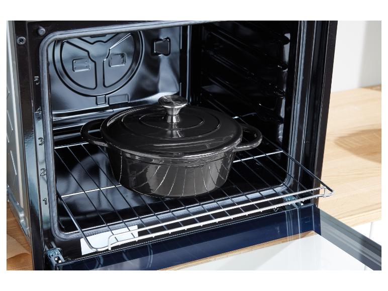 Une cocotte en fonte noire dans un four.