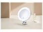 Un élégant miroir de maquillage rond avec éclairage LED et ventouse.