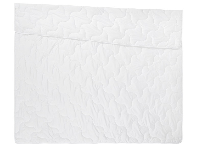 Une couette blanche avec un motif brodé.