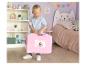 Un garçon tient une mallette de jouets rose Gabby's Dollhouse dans une chambre d'enfant.