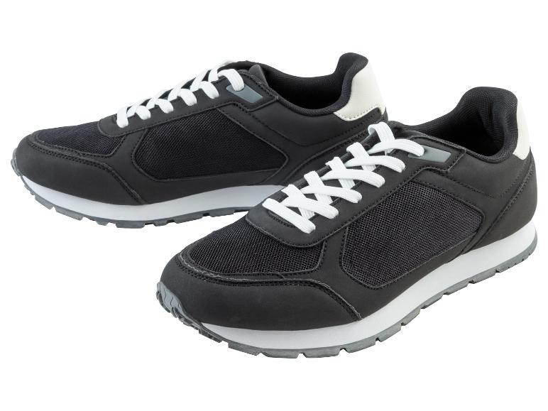 Deux baskets noires avec des lacets blancs.