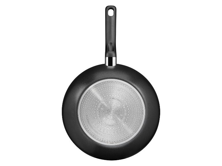 Poêle noire avec manche, vue du dessous, avec technologie à induction.