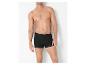 Torse d'un homme portant un boxer noir sur fond blanc.