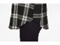 Chemise à carreaux noirs et blancs sur pantalon foncé.