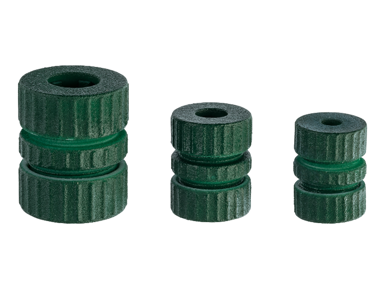 Trois piles de pièces cylindriques vertes en plastique de différentes hauteurs.