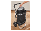 Une personne range un sac isotherme dans un chariot de courses pliable.