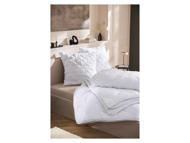 Couette 4 saisons LIVARNO home sur un lit avec des oreillers