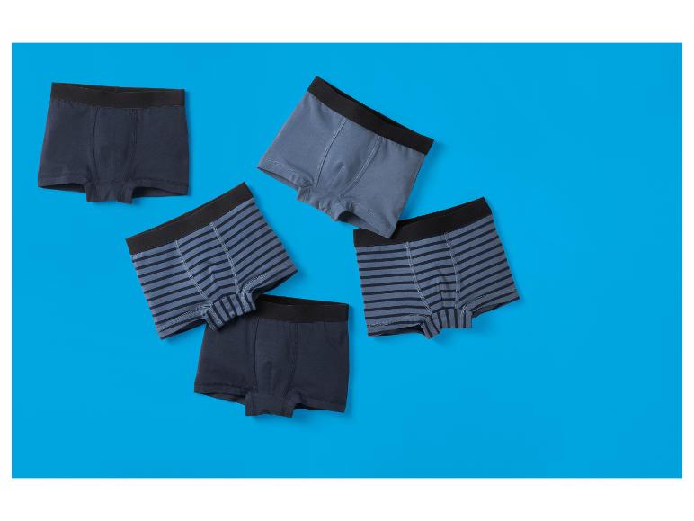 Cinq boxers pour hommes sur fond bleu.