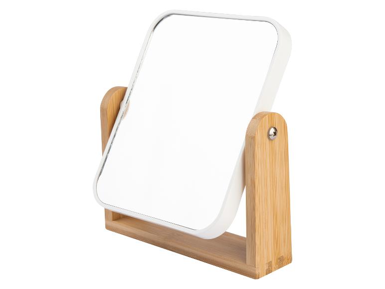 Un miroir de maquillage blanc avec un support en bois