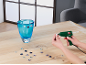 Bricolage avec pistolet à colle et pierres de verre sur une surface en bois, décorant un vase bleu.