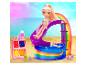 Une poupée en maillot de bain glisse dans une piscine arc-en-ciel avec des accessoires sur une plage.