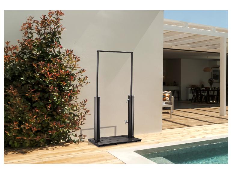 Douche extérieure avec cadre noir et base en bois à côté d'une piscine et de plantes vertes.