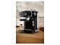 Machine à expresso noire sur un comptoir en bois avec grains de café et café moulu