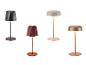Quatre lampes de table portables aux designs et couleurs variés, dont noir, terre cuite, beige et cuivre.