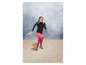 Femme courant en vêtements de sport et en baskets sur le sable.