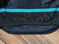 Une veste bleu foncé avec une bande turquoise.