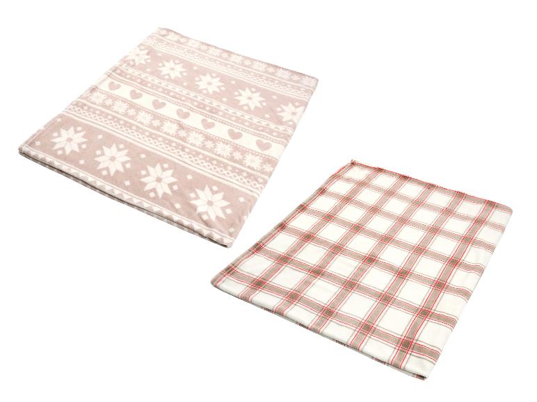Deux couvertures douces, une avec des motifs de flocons et de cœurs, l'autre à carreaux.