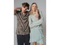 Un homme et une femme posent en tenue d'été : il porte une chemise à rayures et elle une robe verte.