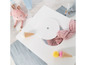 Une table de jeu avec un jouet lapin en peluche, une couverture rose et une glace.