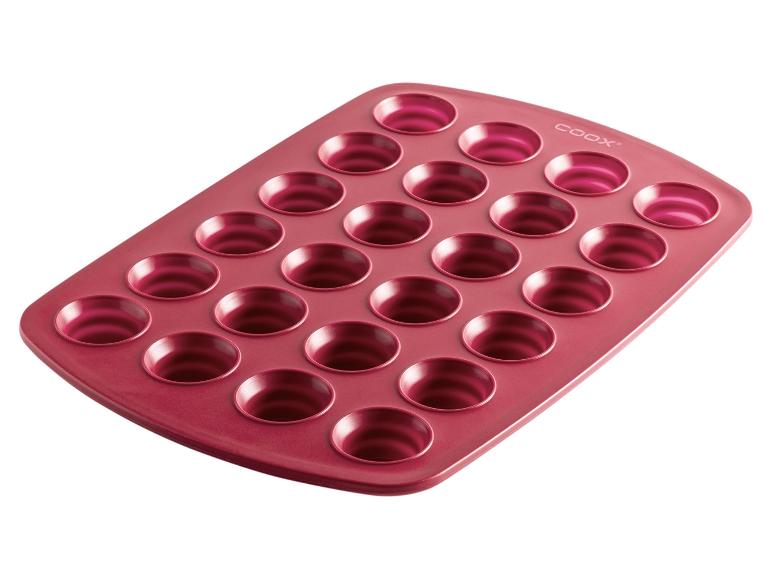 Un moule à pâtisserie rose avec 24 cavités pour cuire de petits gâteaux ou des muffins.