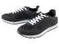 Deux baskets noires avec des lacets blancs.