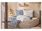 Chambre douillette avec lit rembourré, linge de lit bleu floral et étagères en bois.