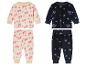 Deux pyjamas pour enfants : l'un avec un motif d'arbres de Noël, l'autre avec des flocons de neige.