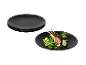 Assiettes noires avec côtelette d'agneau et légumes.