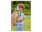 Un enfant avec un cheval en bois jouet dans un jardin.