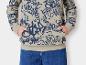 Un sweat-shirt beige à imprimé graffiti bleu et un jean bleu.