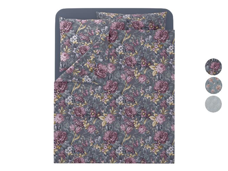 Parure de lit florale avec oreillers assortis sur fond gris.