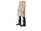 Personne en imperméable beige, jean et bottes en caoutchouc noires.