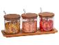 Herbes, sel rose de l'Himalaya et fraises lyophilisées dans des pots en verre avec couvercles en bois.