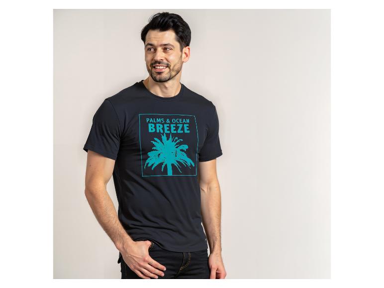 Homme en t-shirt noir avec un palmier turquoise et l'inscription 'PALMS & OCEAN BREEZE'.