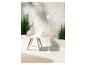 Lampe sur pied blanche et fauteuil design moderne avec plantes vertes.