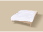 Lit simple avec couette blanche et drap beige sur fond neutre.