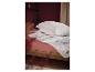 Oreillers et couette blancs Polygiene sur un lit rose.
