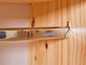 Une tringle à vêtements chromée fixée à un placard en bois.