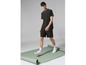 Un homme porte une casquette noire, un t-shirt vert et un short à imprimé léopard.