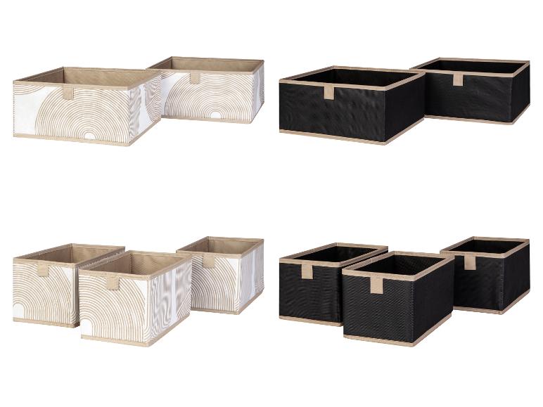 Quatre boîtes de rangement, deux avec un motif de rayures beiges et deux noires.