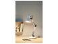 Une lampe de bureau blanche avec une base noire sur un bureau en bois.