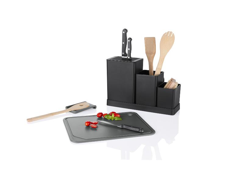 Une planche à découper, un couteau, une cuillère en bois et un bloc à couteaux.