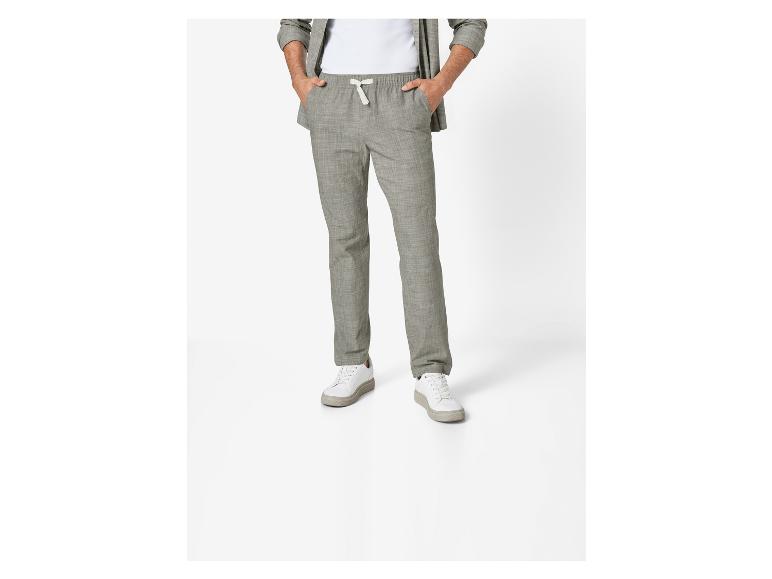 Pantalon chino gris et baskets blanches pour homme.