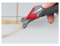 Une main utilise un outil gris et rouge pour enlever le coulis entre les carreaux.