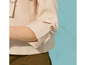 Une veste beige avec des boutons et un pantalon vert.