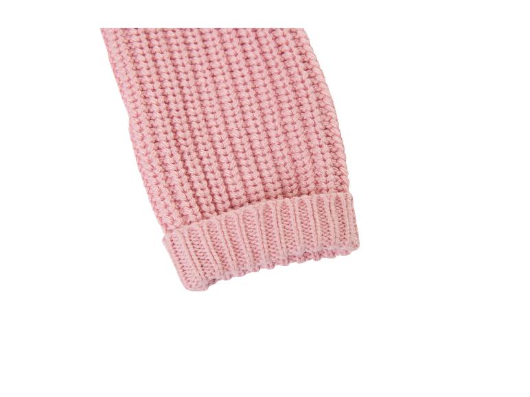 Détail d'une manche de pull en maille rose pâle avec poignet côtelé.