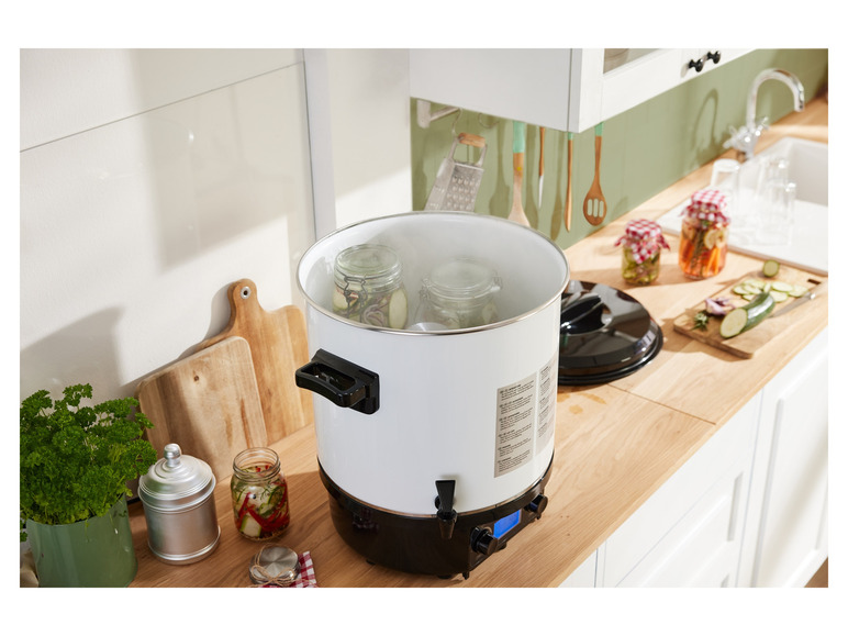 Une machine à bain-marie blanche avec des bocaux en verre pour la mise en conserve des aliments.